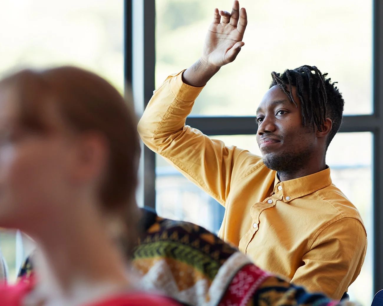 man heeft arm omhoog om vraag te stellen