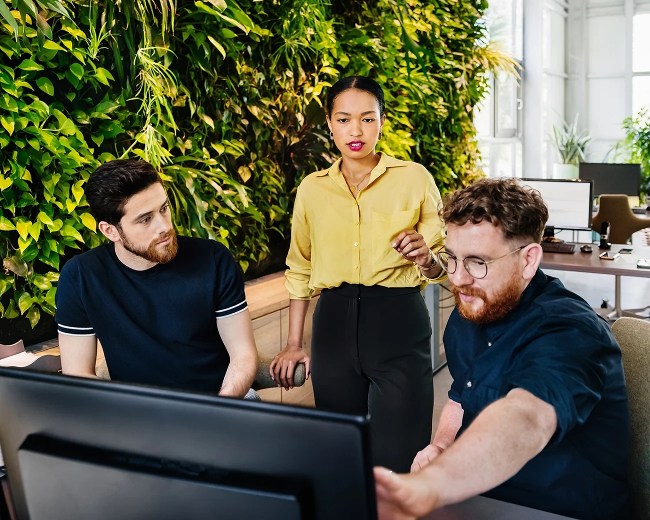 Groep samenwerkende mensen achter computer