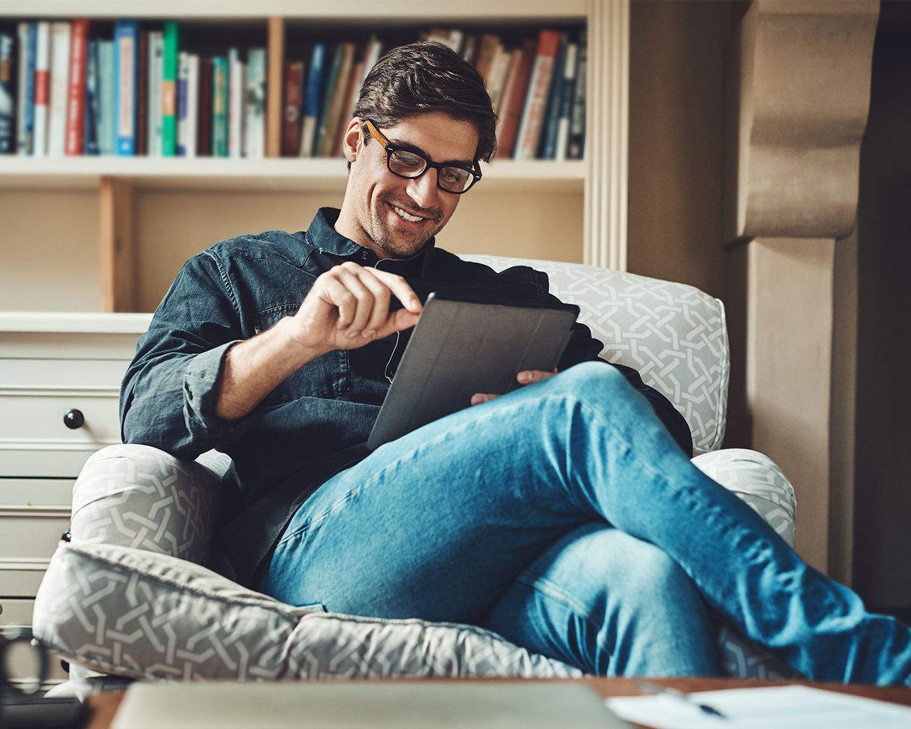 Man zit op stoel en kijkt op tablet