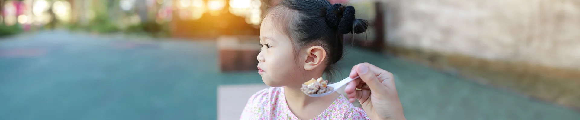 Kind draait hoofd weg van eetlepel.