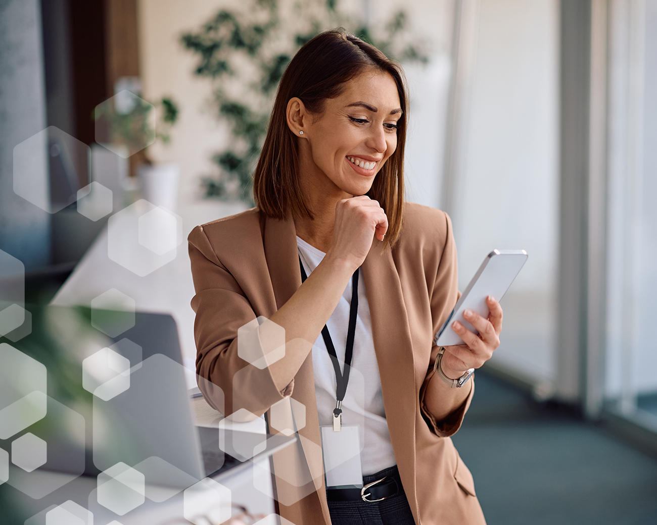 Financieel specialist bekijkt bericht telefoon achter laptop