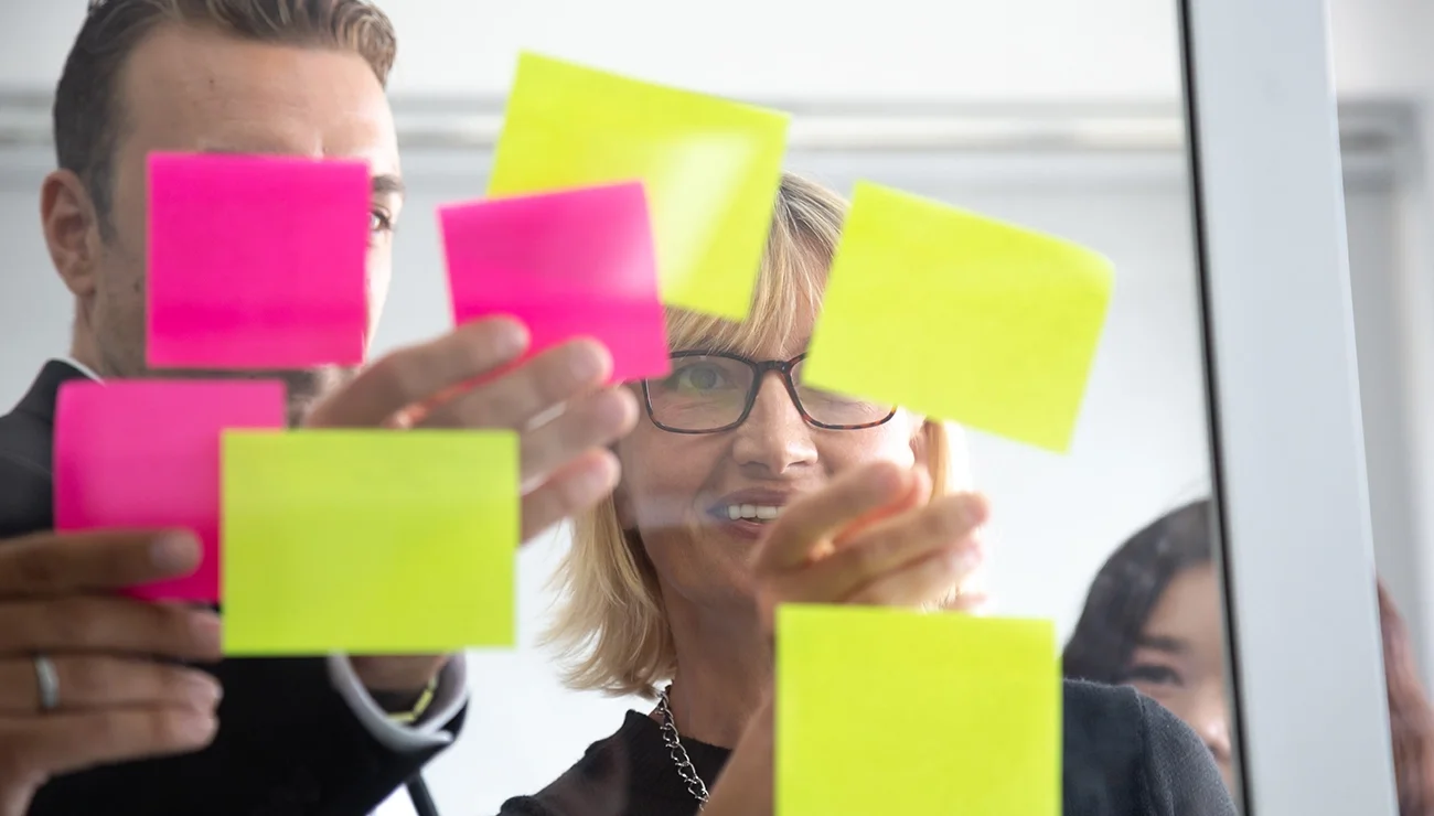 Team die bezig is met post its ophangen