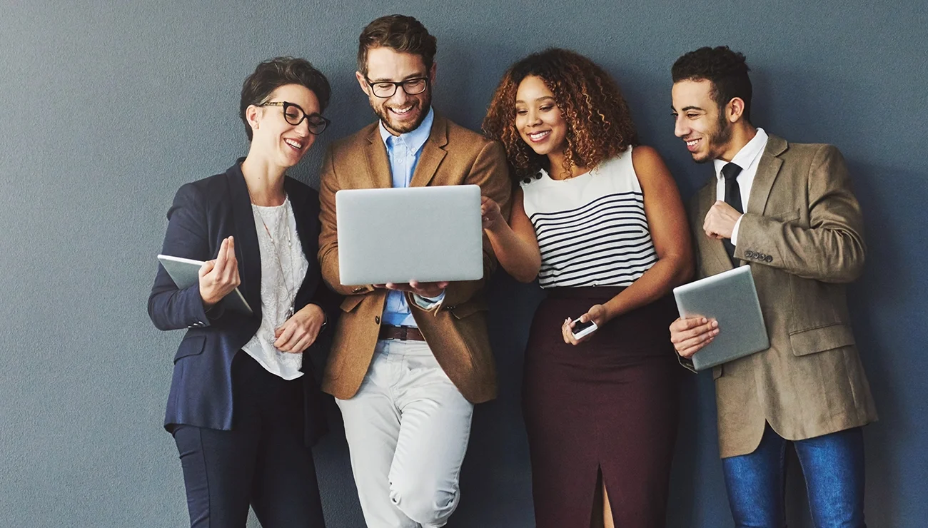 Groep collega’s kijkt samen naar een laptop