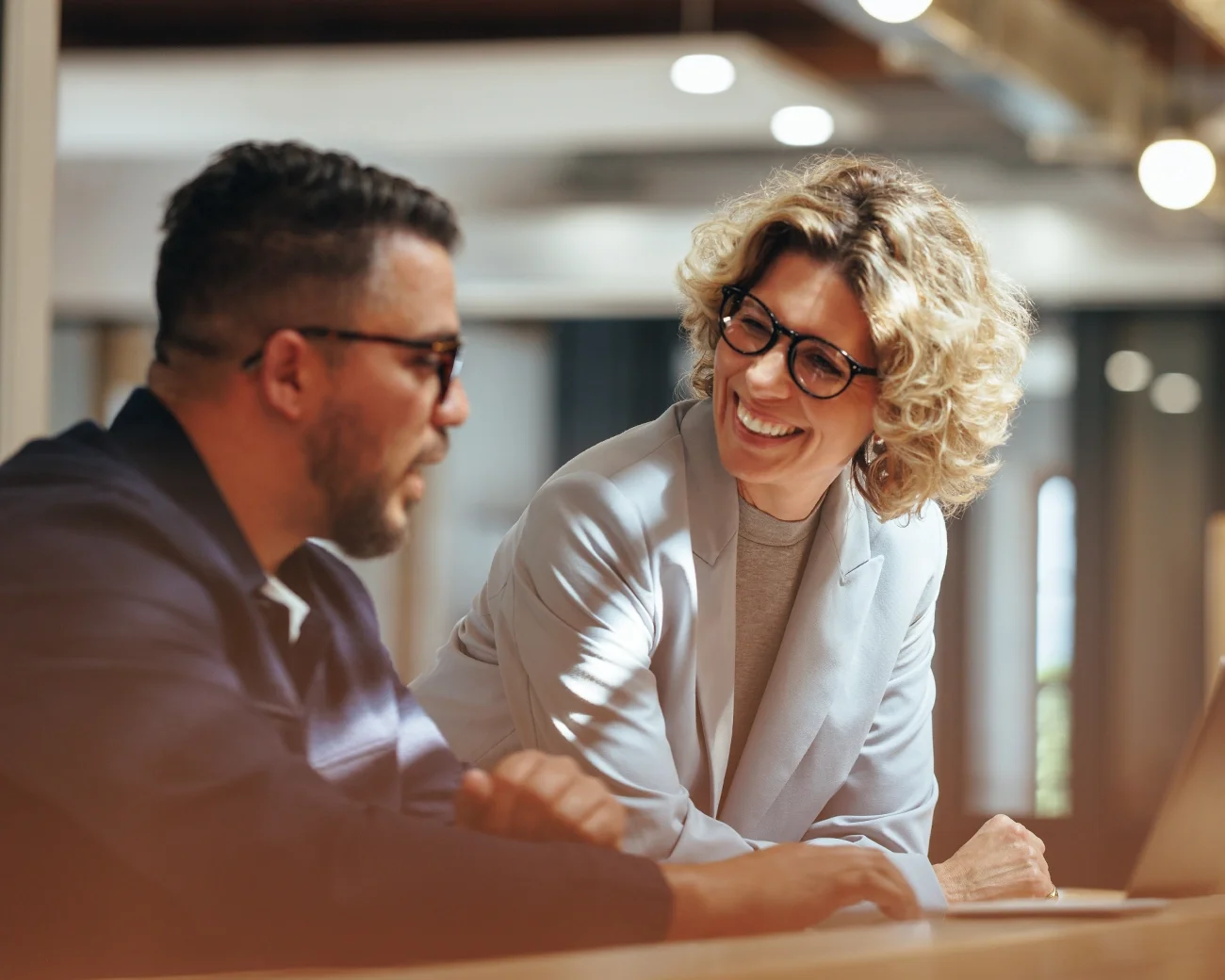 Vrouw in gesprek met man bij bureau