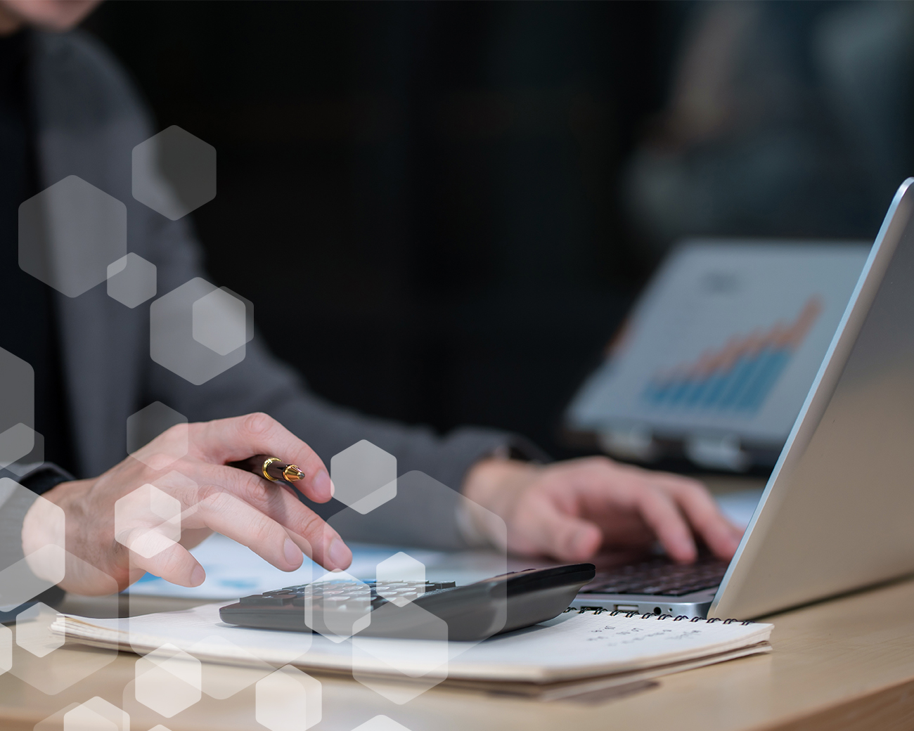 Medewerker analyseert financiële gegevens met rekenmachine en laptop als voorbereiding op rol van financial controller