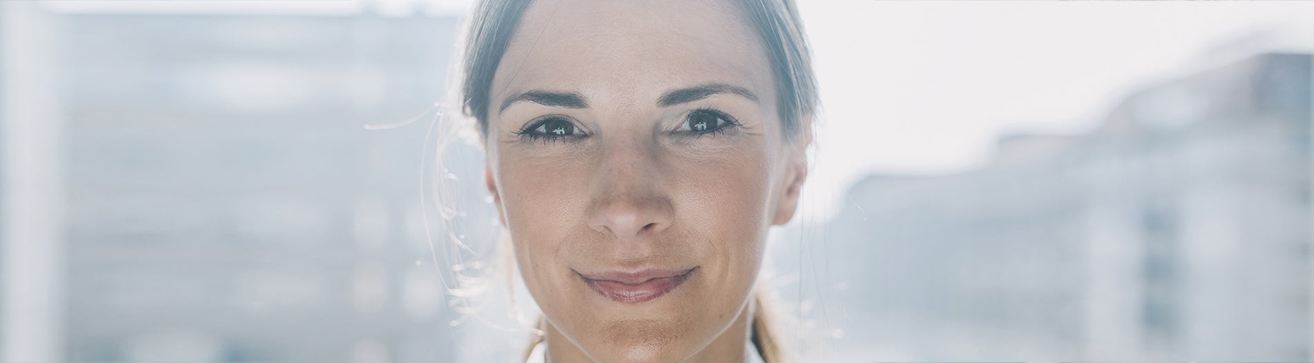 Vrouw kijkt lachend in de camera