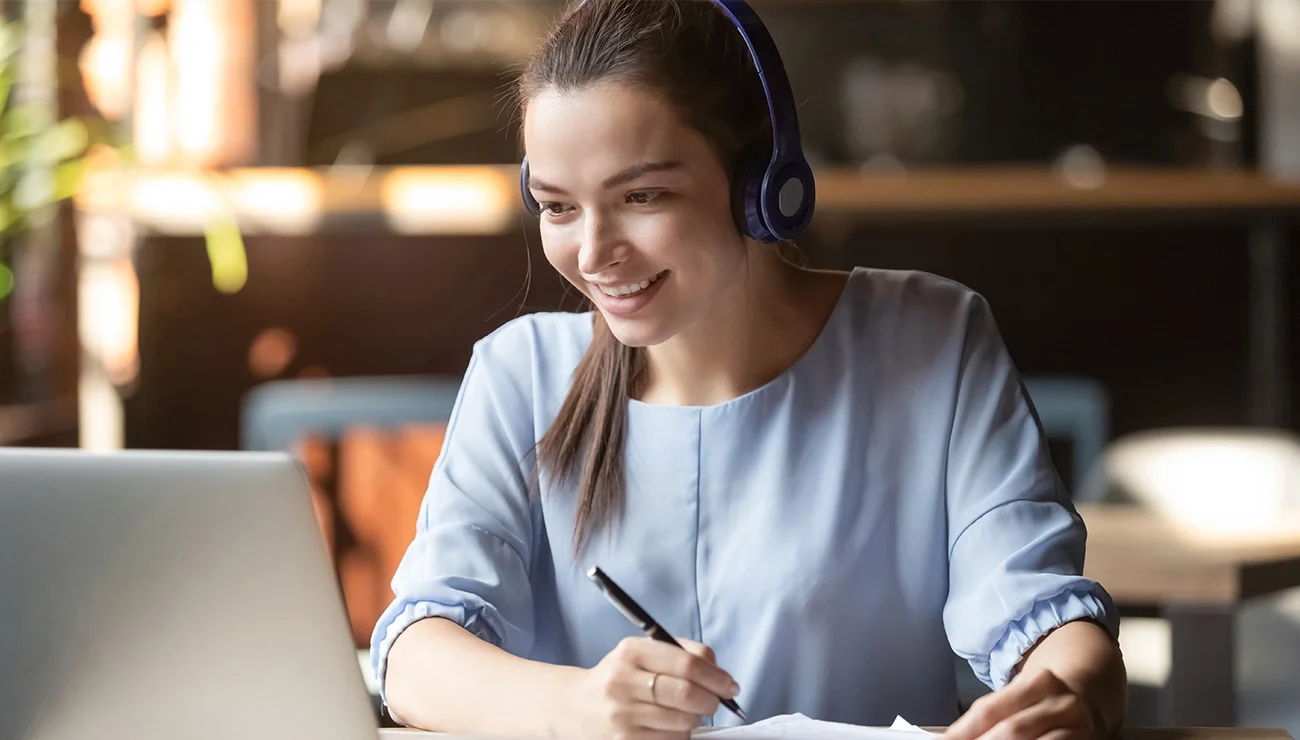 Vrouw maakt notities achter de laptop