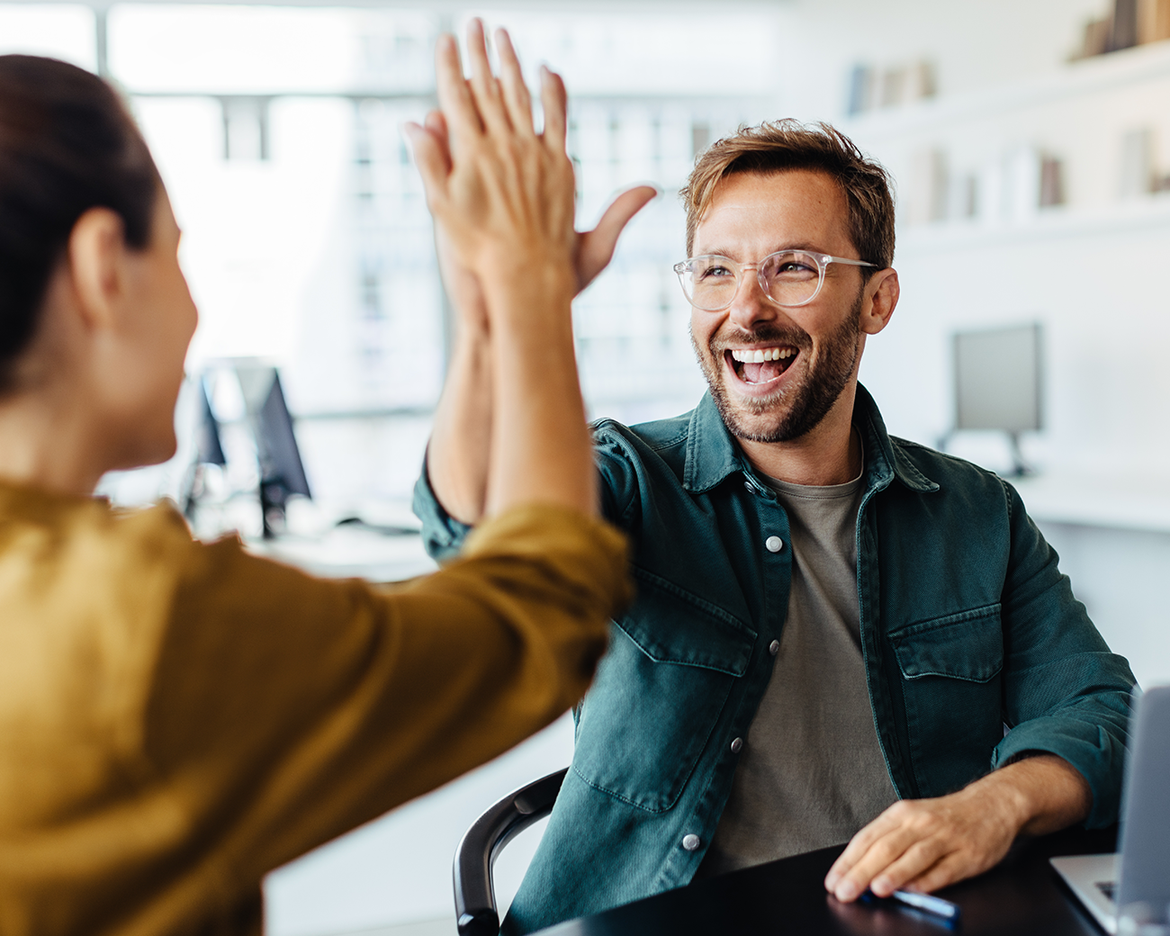 Man en vrouw geven elkaar een high five voor goede samenwerking.