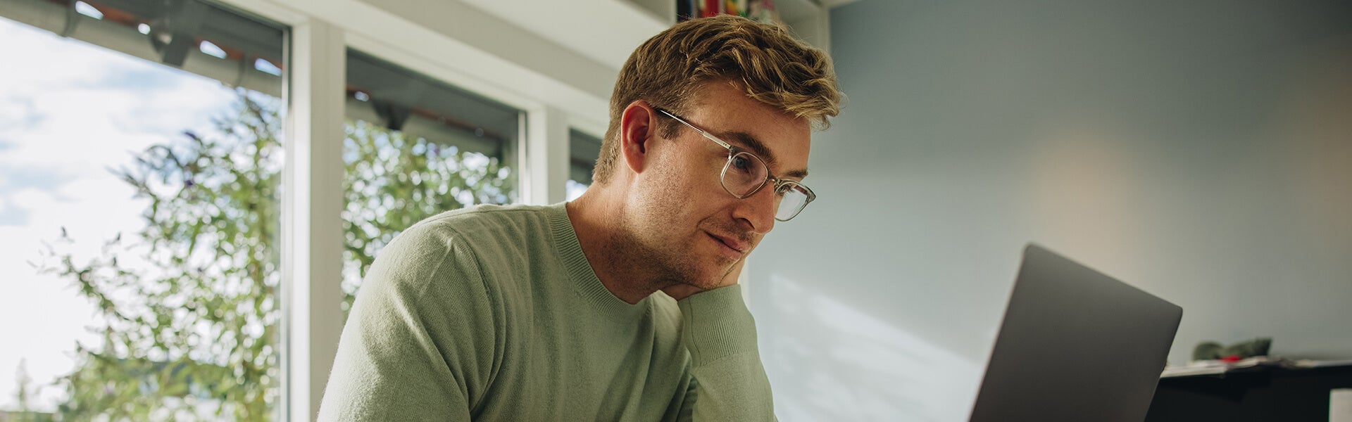 Man met bril achter laptop