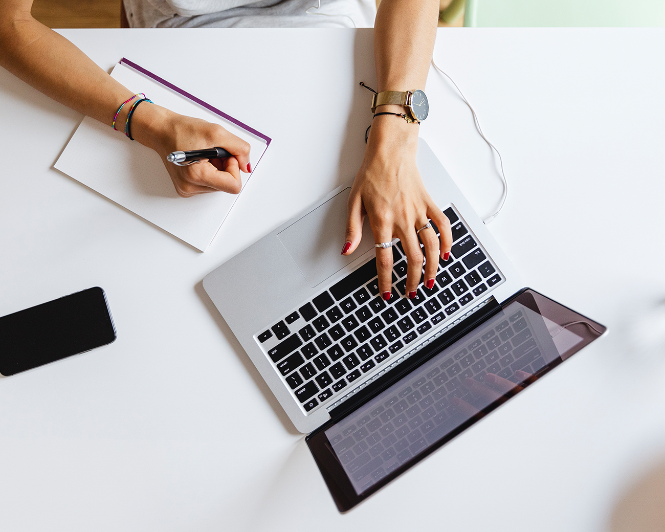 Vrouw werkt op laptop en schrijft kladblok