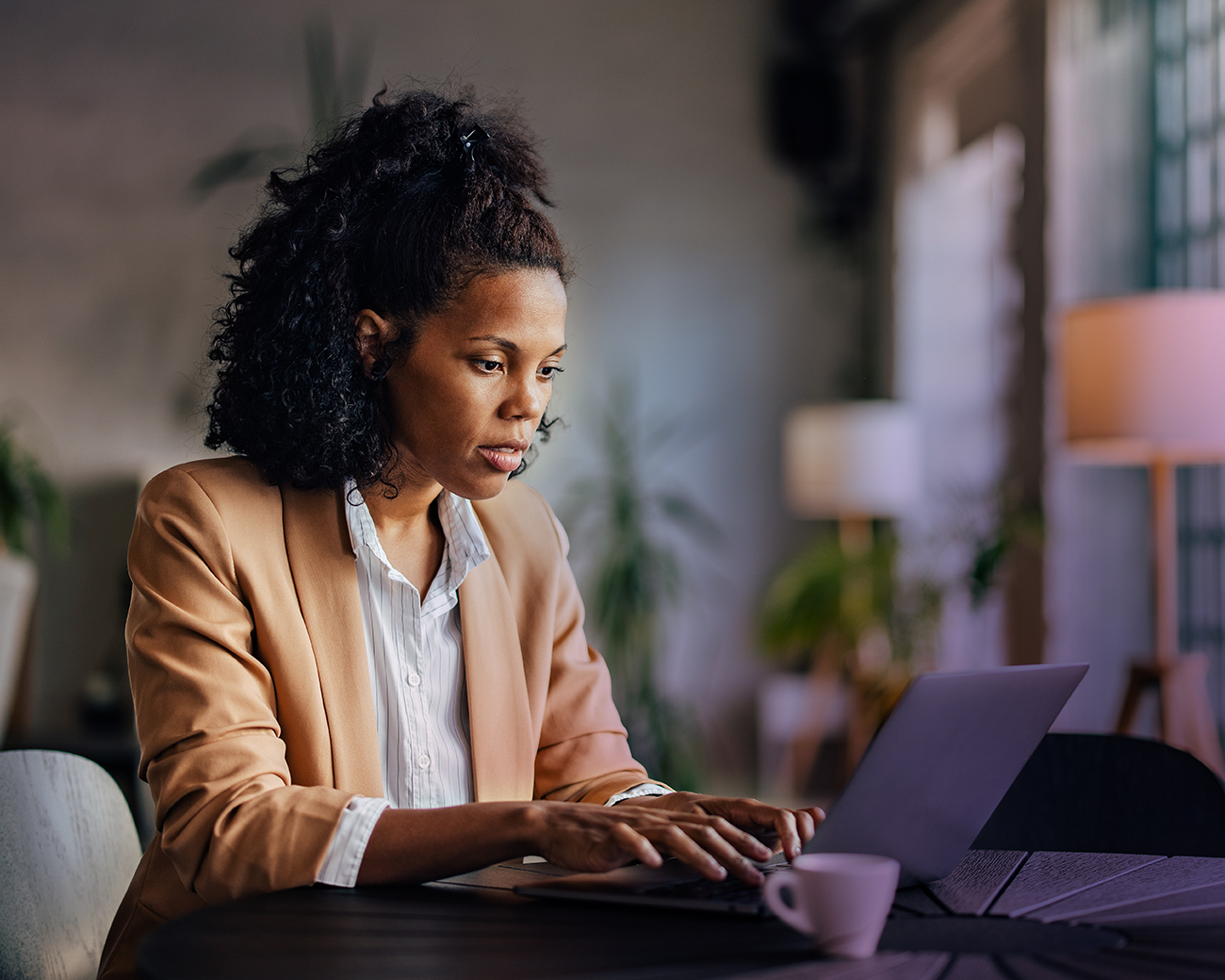 Vrouw achter laptop in kantooromgeving