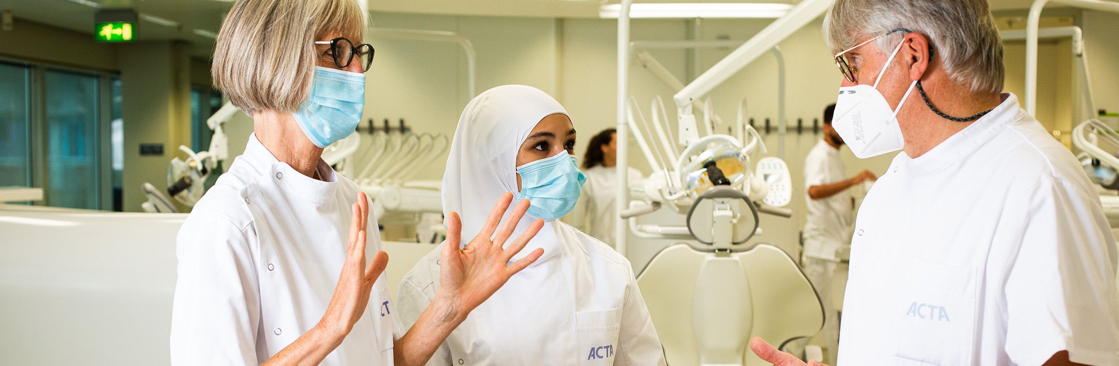 Teachers discuss between the dentist chairs