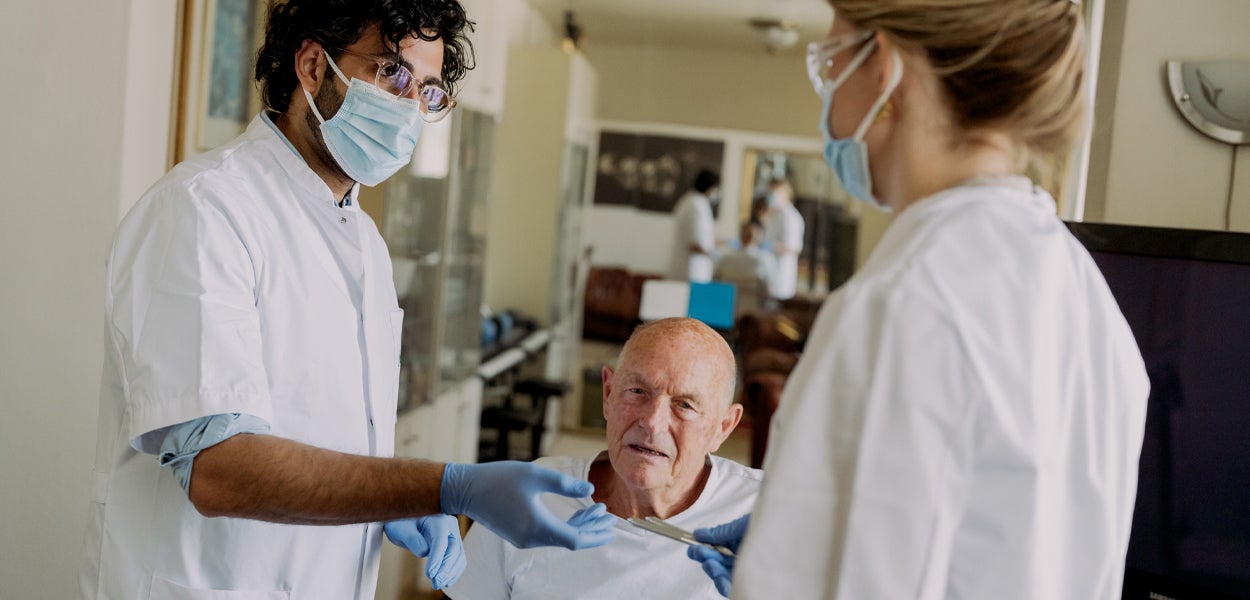 Studenten behandelen oudere patiënt.