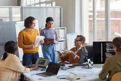 Employees in a bank setting discussing with eachother