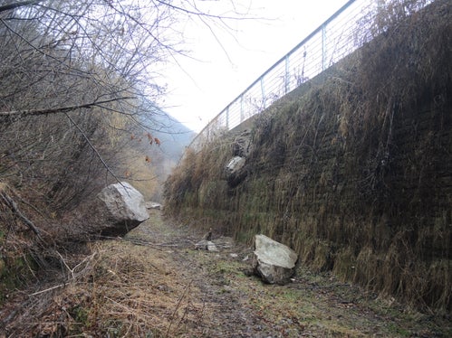 Impatto di un blocco di circa 5 metri cubi sul vallo paramassi a monte della pista ciclabile nella tratta Prato Isarco – Cardano e della strada statale del Brennero poco a Nord dell’uscita A22 “Bolzano Nord”. Il crollo si è verificato il 8 marzo 2018 e mostra come l'altezza del lato monte del tomo-vallo di 6,5 m é ampiamente giustificata.