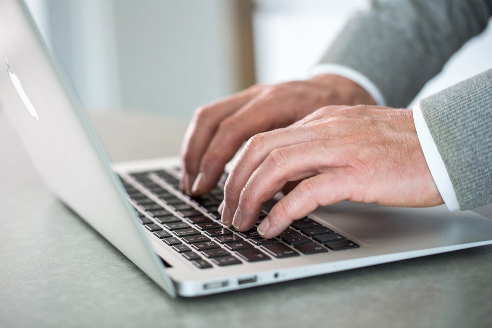 typende handen op laptop