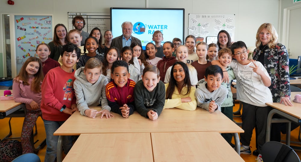 Kinderen kijken lachend in de camera.