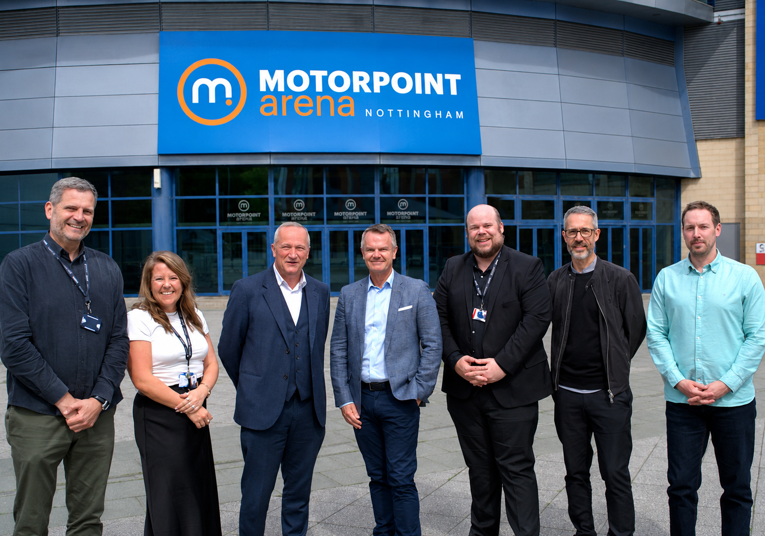 Pictured (L-R):  Matt Appleby, Head of Marketing and Communications at Motorpoint Arena Nottingham, Kylie Costall, Head of Sales and Hospitality at Motorpoint Arena Nottingham,  Martin Ingham, Motorpoint Arena Nottingham CEO, Mark Carpenter, Motorpoint Group CEO, Phil Jones, Commercial Director at Motorpoint Arena Nottingham, Andrew Thomson, Chief Digital Officer at Motorpoint and Alex Howland, Marketing Director at Motorpoint all stood smiling outside of the Motorpoint Arena Nottingham