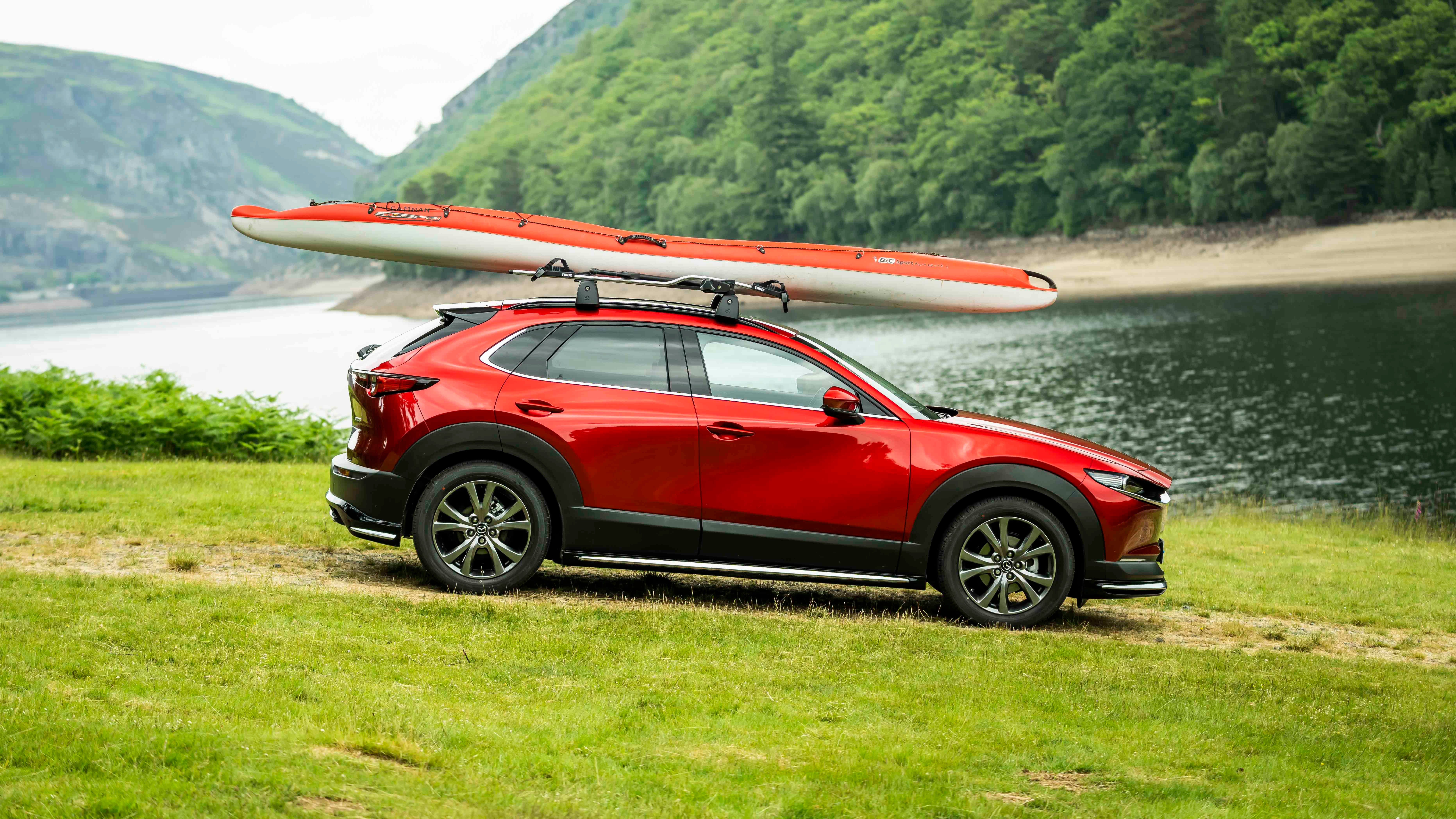 Mazda CX-30 with kayak on roof, next to river