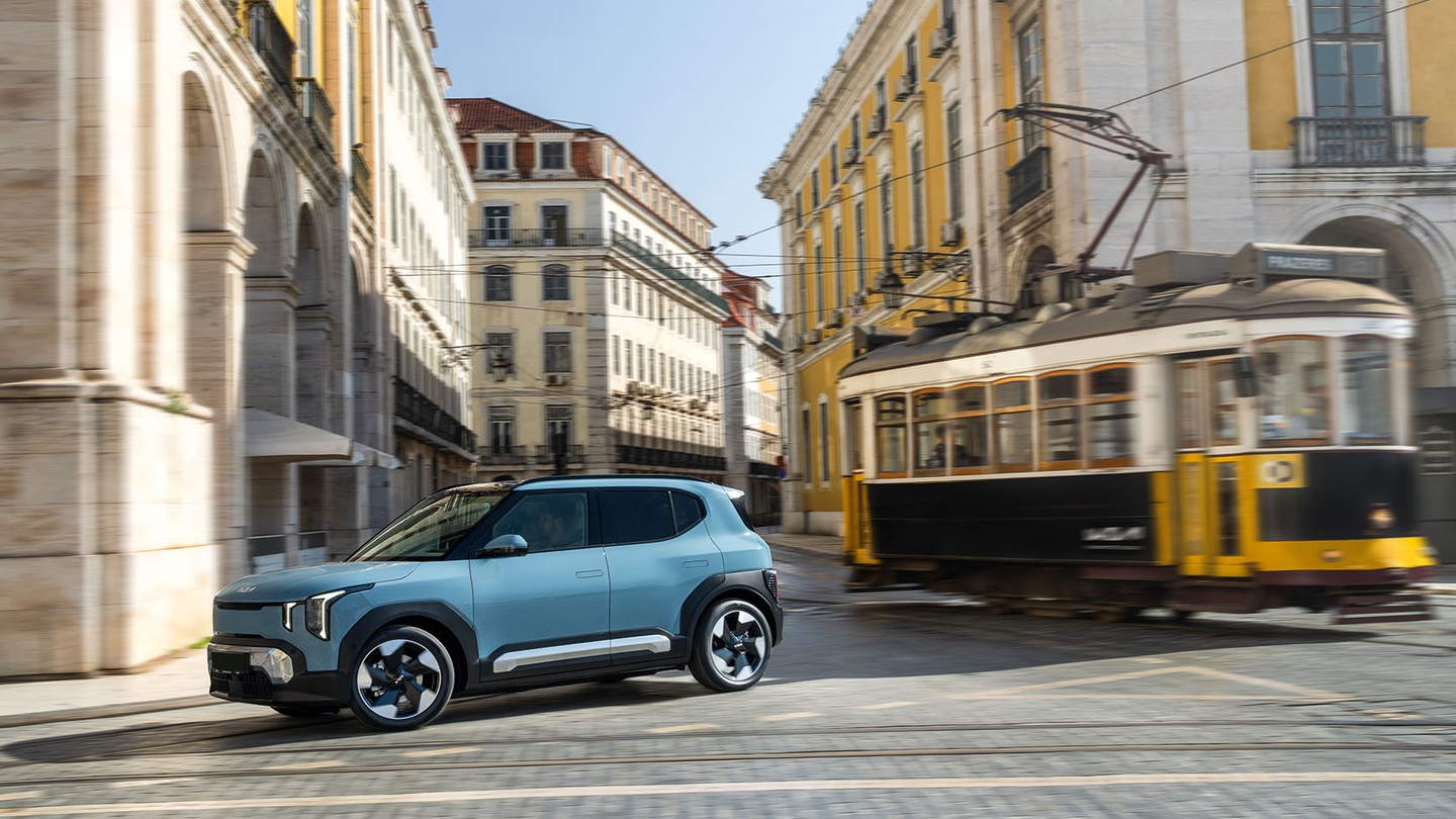 Kia EV2 driving next to tram in Lisbon