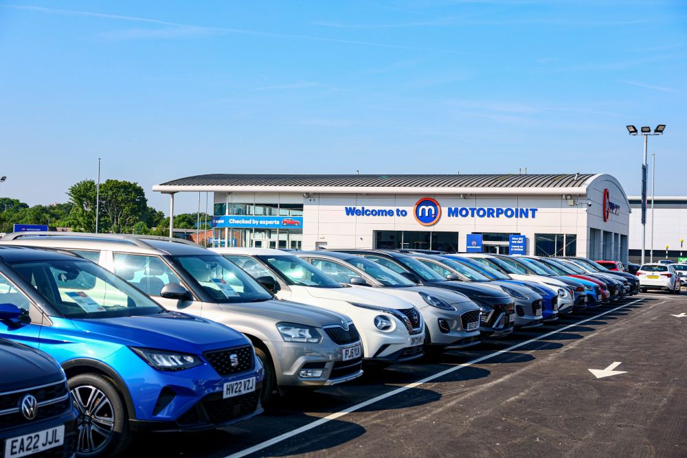 Image of the exterior of Motorpoint Leeds, including cars on the pitch