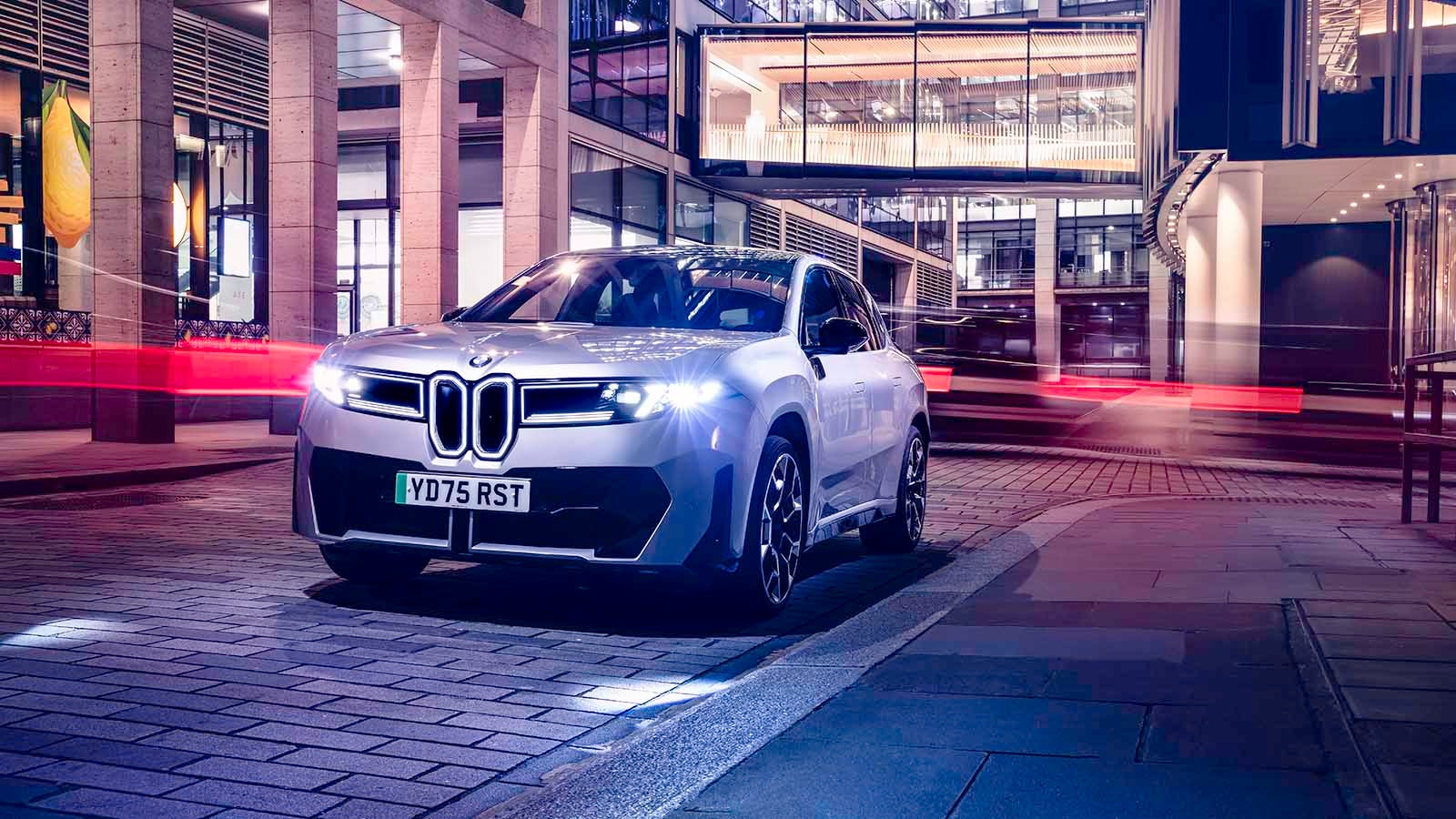 BMW iX3 in silver, static long-exposure front shot in the city