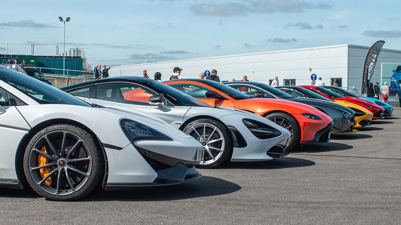 Line of Aston Martin and McLaren sports cars at the British Motor Show