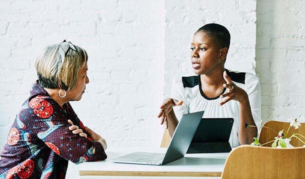  Two women in conversation in an office setting