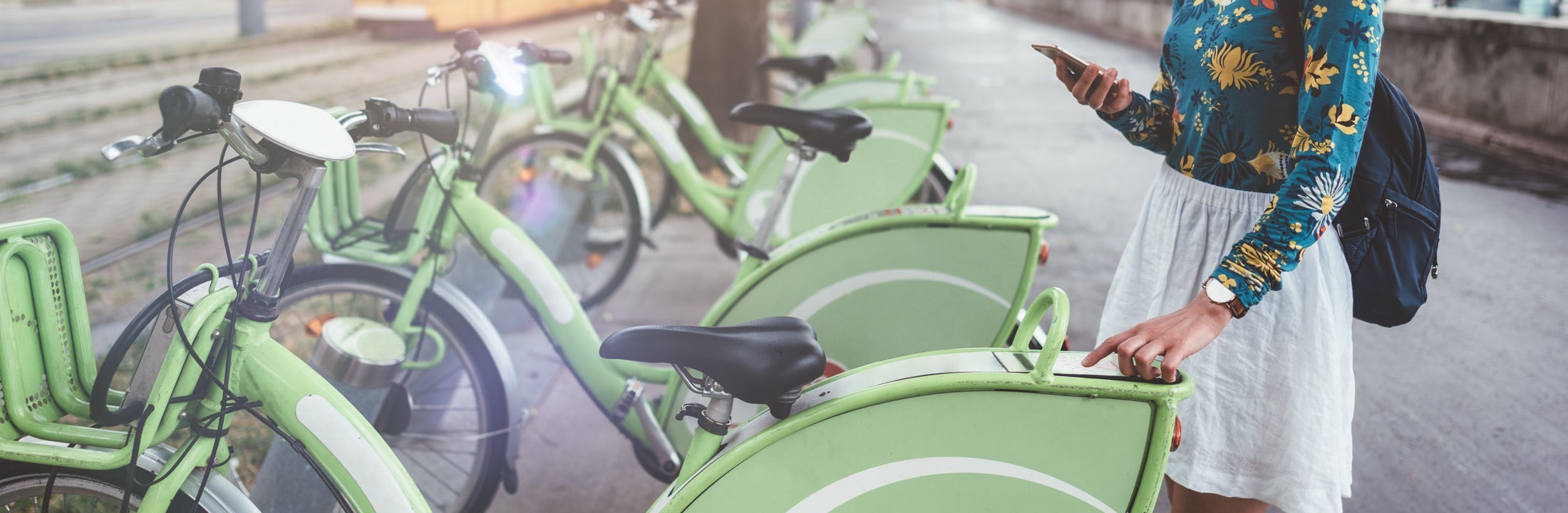 Een jonge vrouw voert een code in op een display op een huurfiets