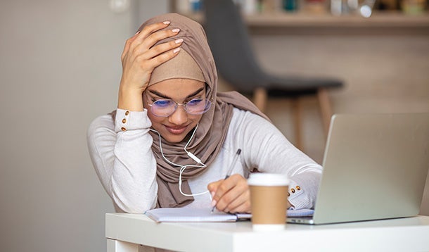 Student aan het schrijven achter een laptop