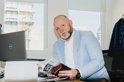 Criminologist Jasper van der Kemp sitting at a desk holding a book