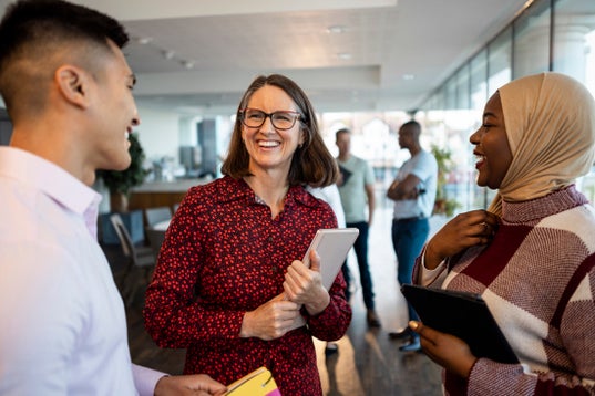 Three alumni smiling and talking
