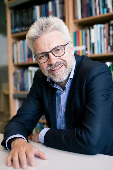  Govert Buijs, zittend aan bureau, met op de achtergrond een boekenkast