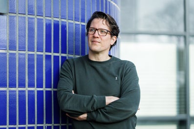 A man leans against a wall