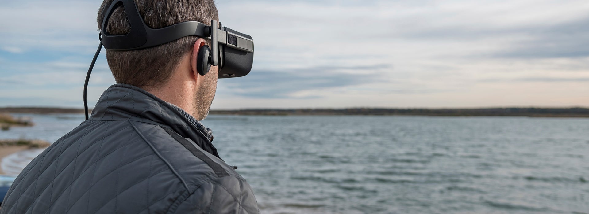 Een man kijkt over het water met een VR-bril 
