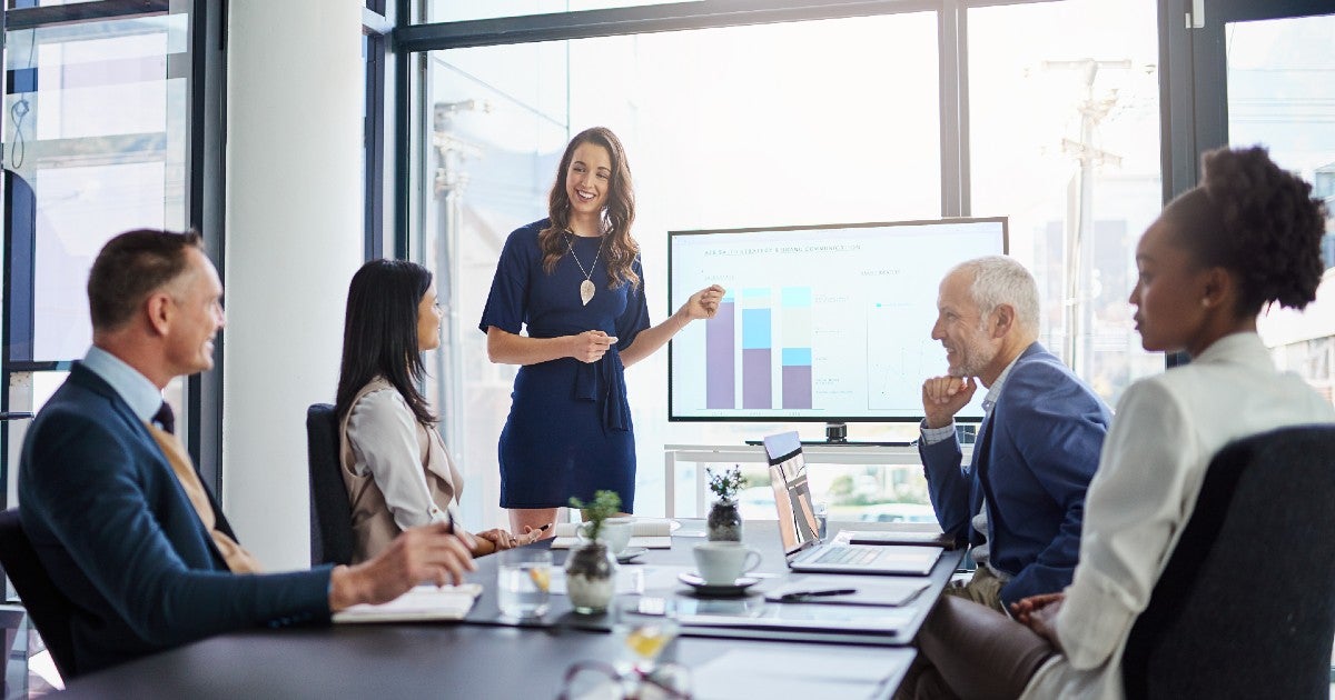 A woman presenting a slide deck to colleagues in the office