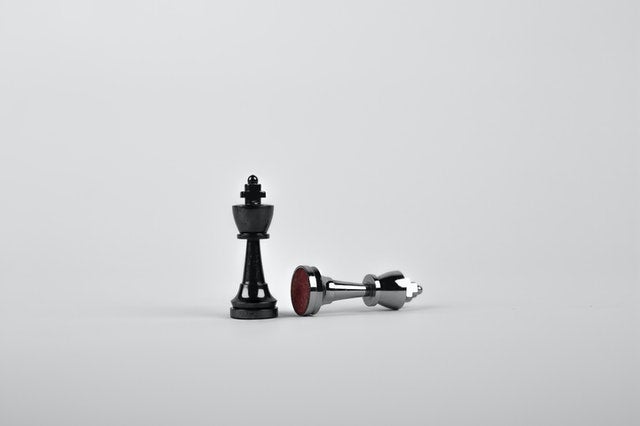 Two chess pieces with one fallen