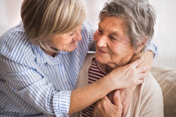 Two elderly women hugging