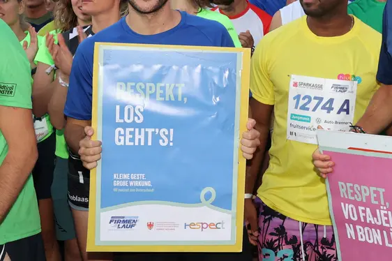 Die Teilnehmenden machen mit Plakaten in Deutsch, Italienisch und Ladinisch die Botschaft der RESPECT-Kampagne sichtbar. (Foto: Running BZ)