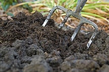 Adding mushroom compost to garden borders at 911 Wisley. Image: Tim Sandall/911