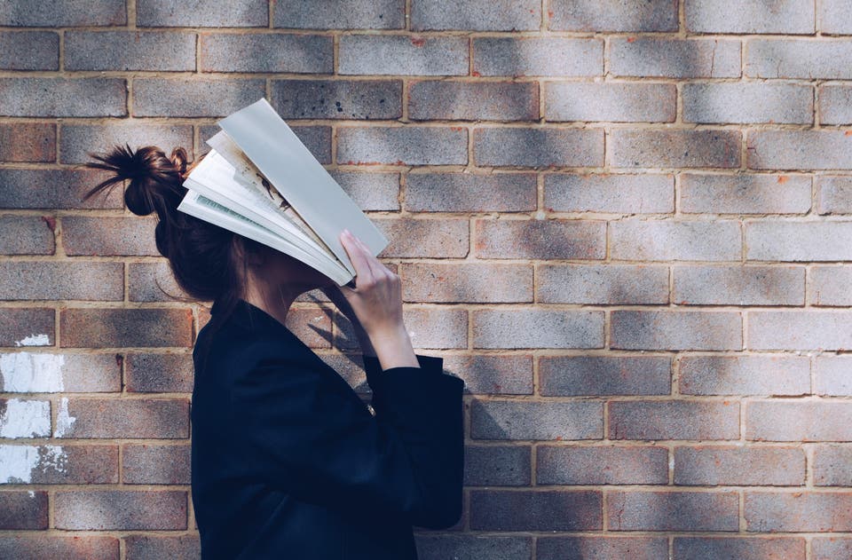 Woman with a book to her face