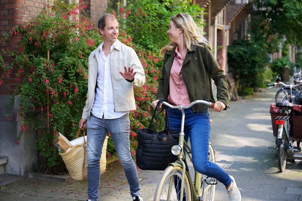 lopende man en fietsende vrouw op de stoep