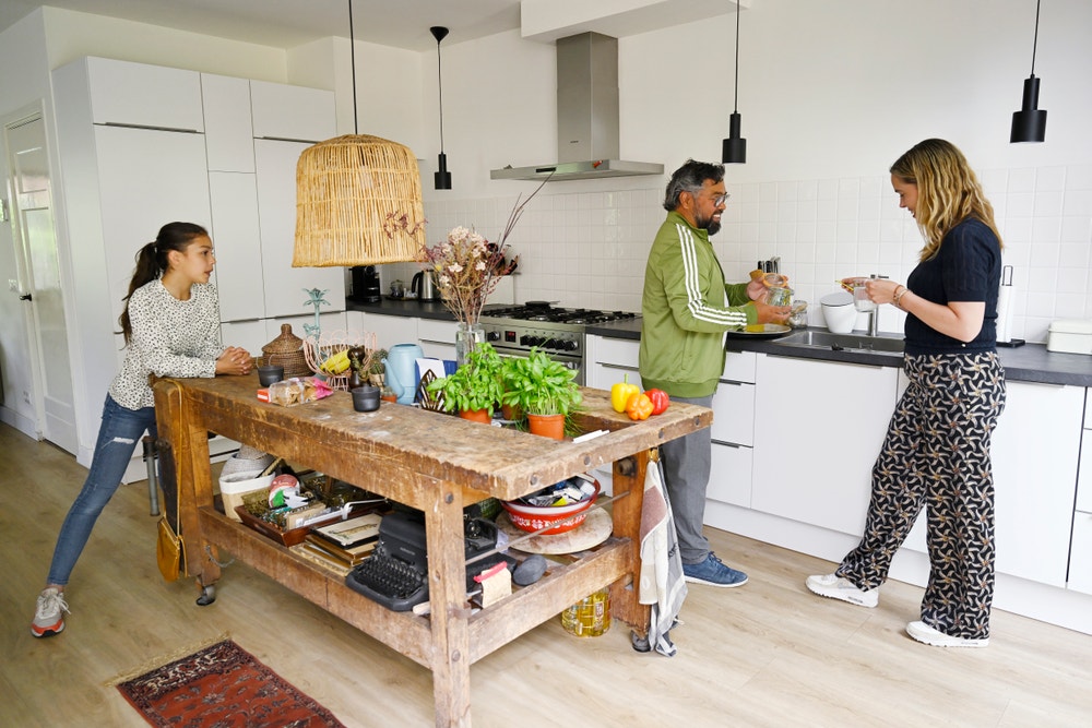 man vrouw en kind staan in keuken