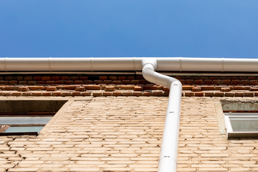 Regenpijp tegen een muur van een huis