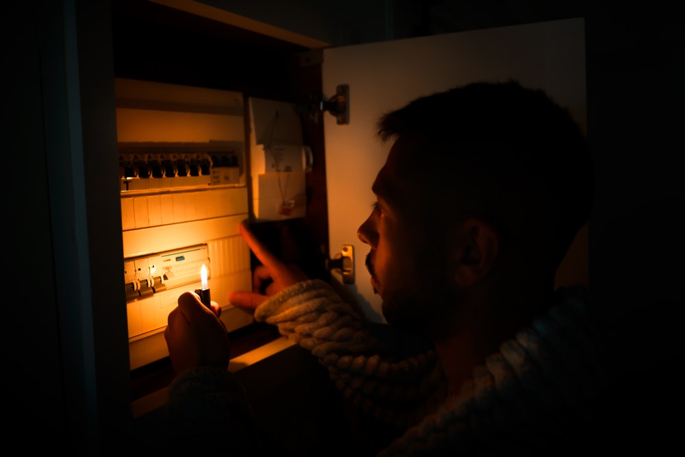 man met aansteker bij meterkast
