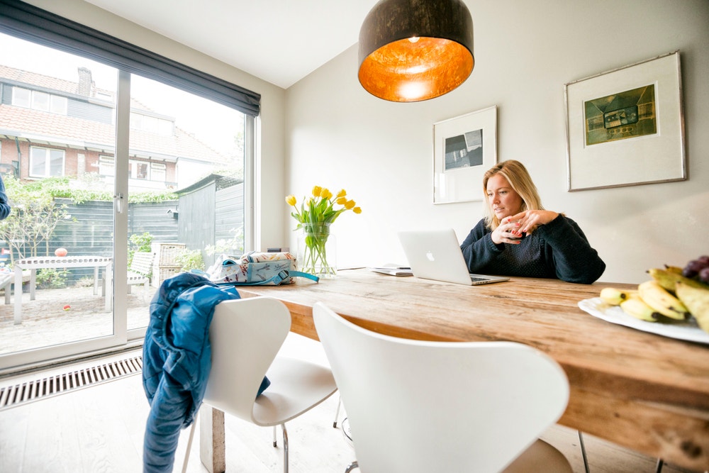 vrouw aan tafel achter laptop