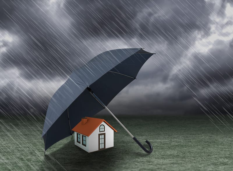 Huis dat beschermd wordt met een paraplu tegen de regen. 
