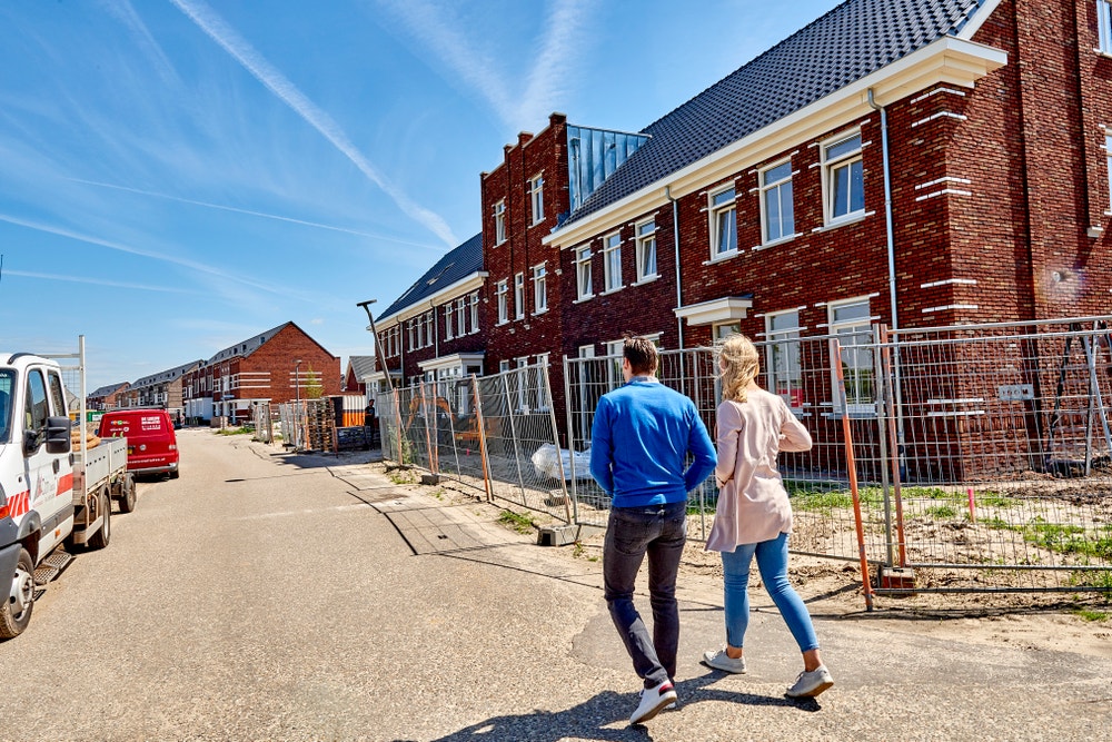 stel loopt over straat nieuwbouwwijk in aanbouw