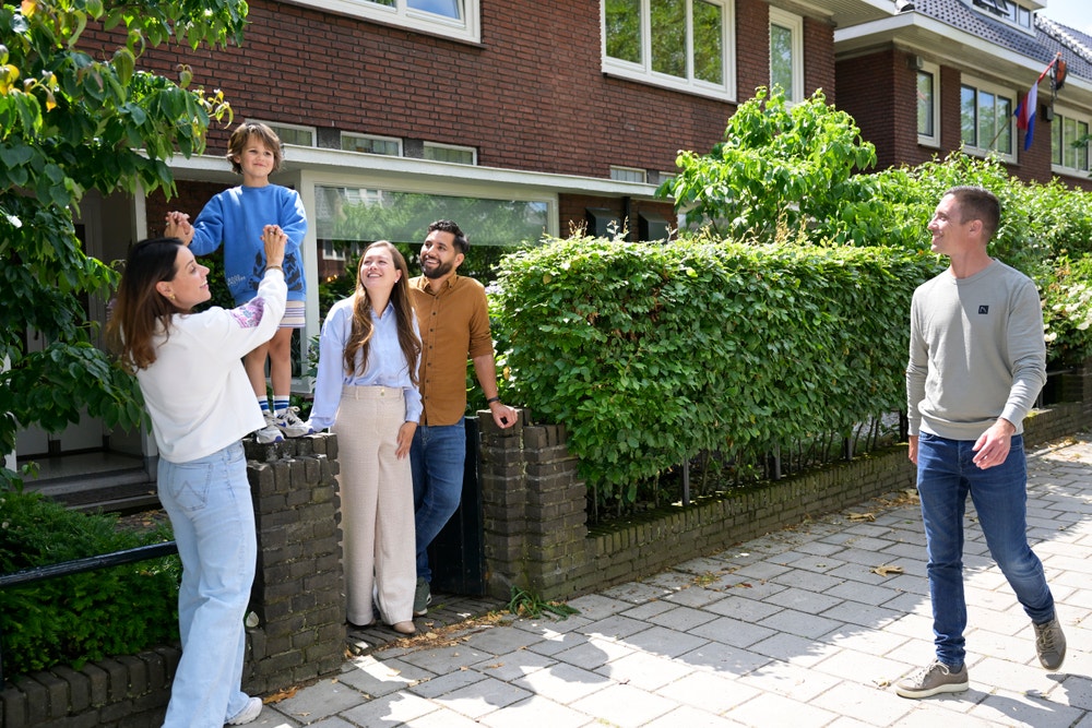 Een aantal buren staan voor hun huis