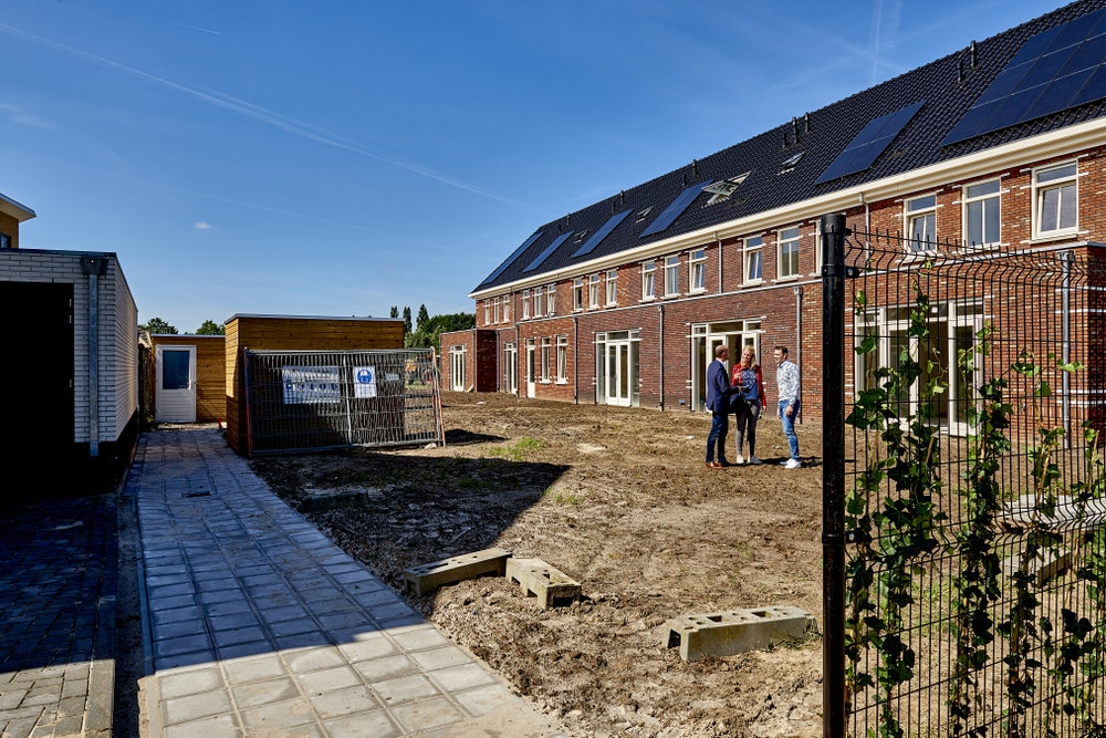 mensen overleggen op grond achtertuinen nieuwbouwwijk
